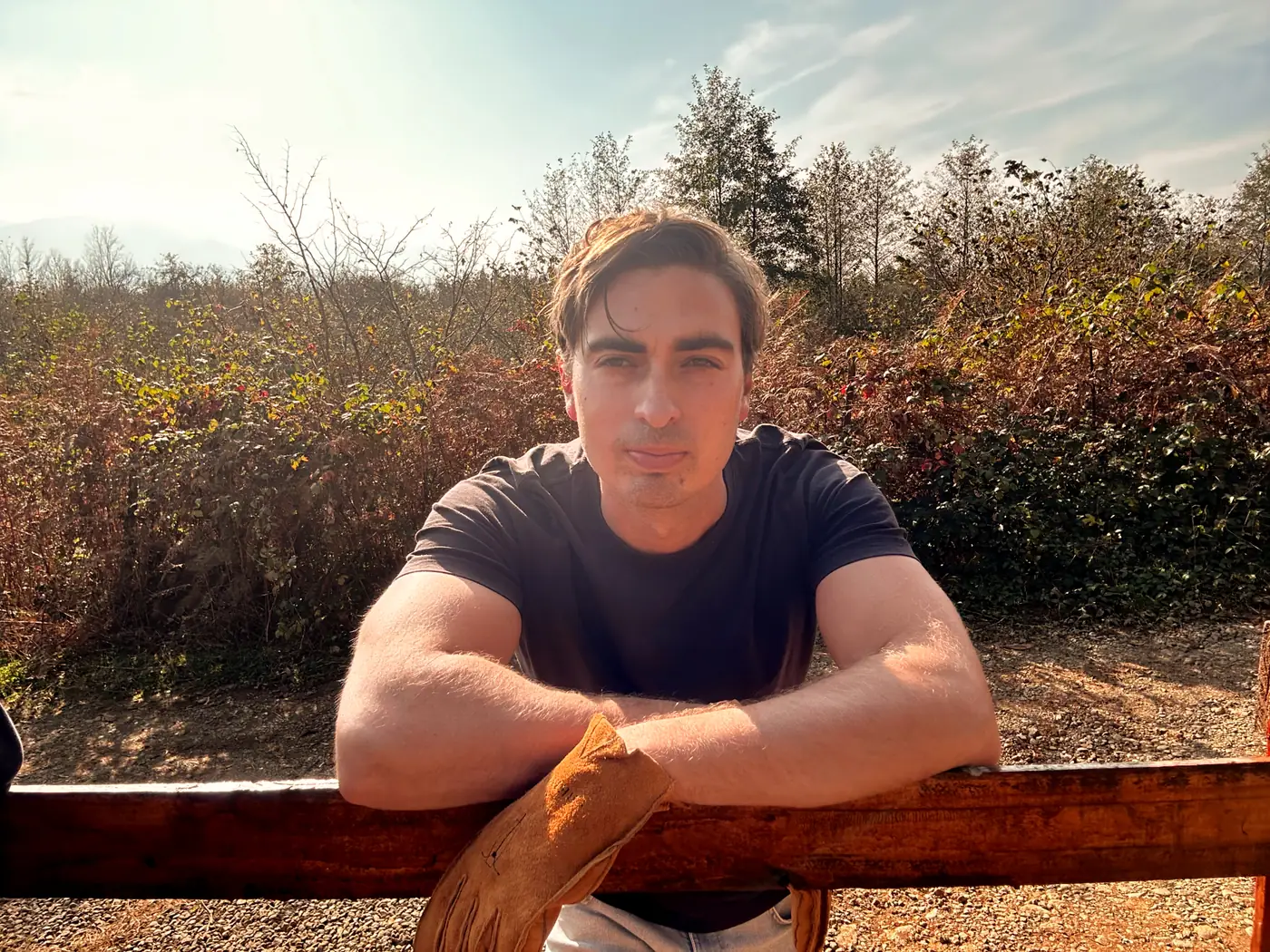 Estevan Knox leaning on a wooden rail at the homestead
